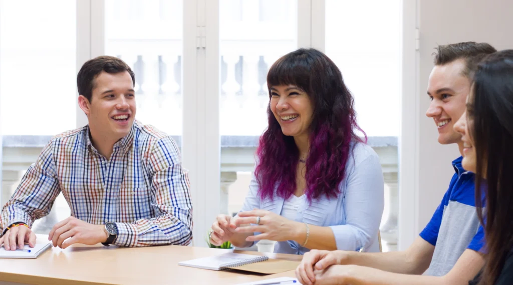 International students smiling and collaborating during a business class at BLC Spain in Madrid.