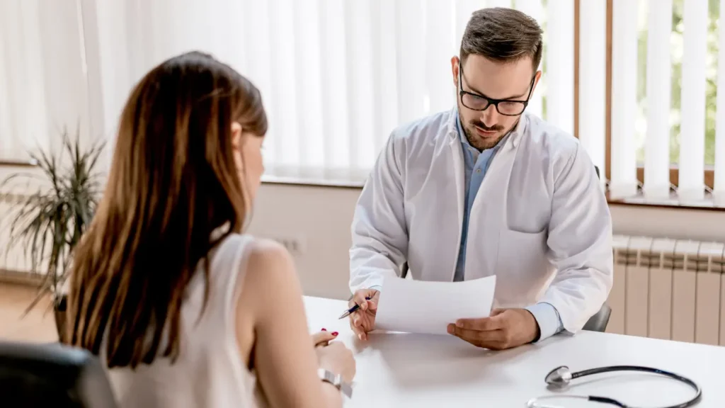 A doctor reviewing documents with a patient at a clinic, representing Spain’s healthcare process for international students.