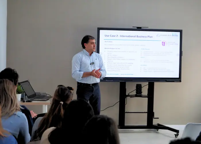 A speaker at BLC Spain campus presenting a workshop on using AI for international business plans and startup strategies.